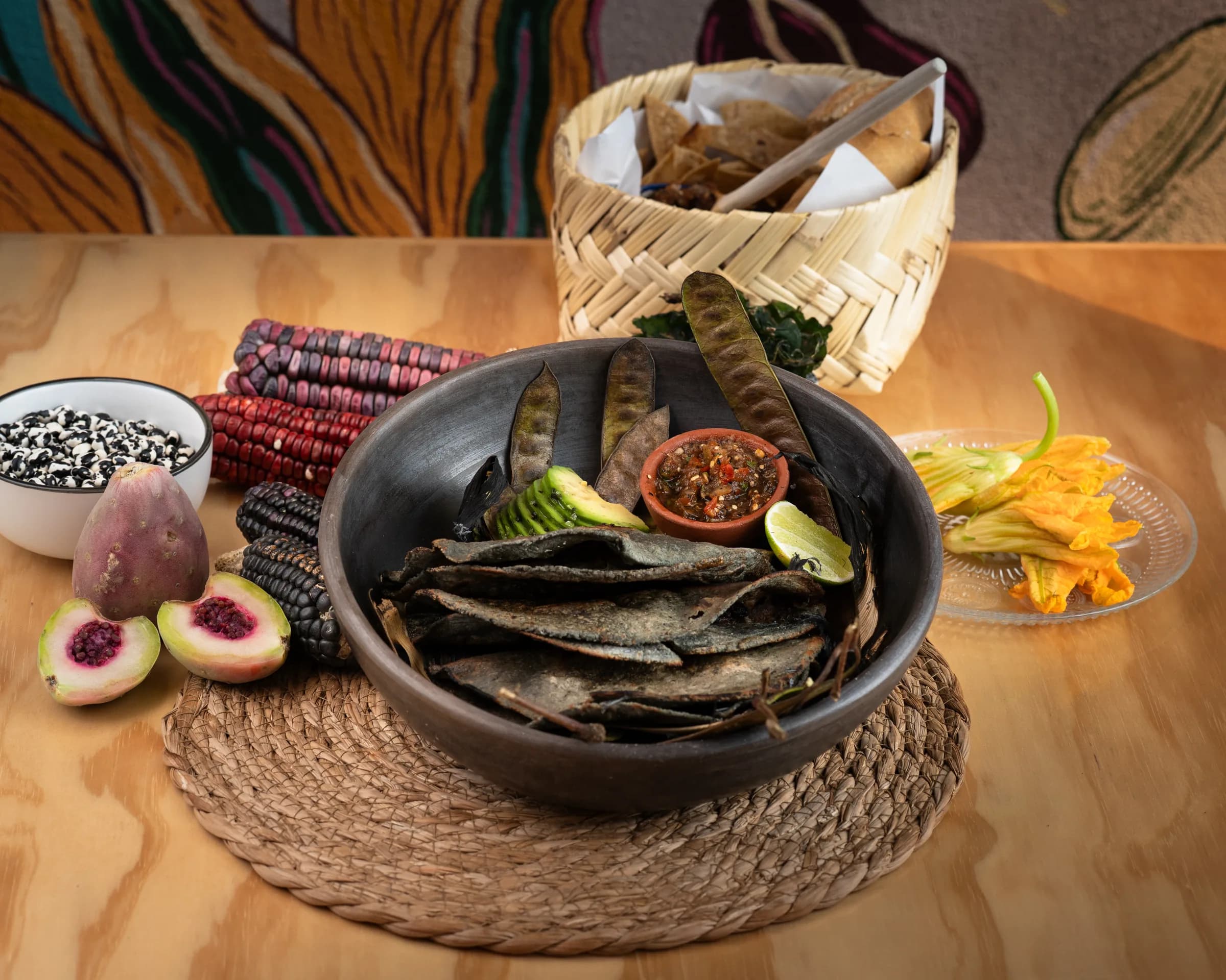 Composición de un plato de tortillas, salsas, canasta y elementos de mesa.