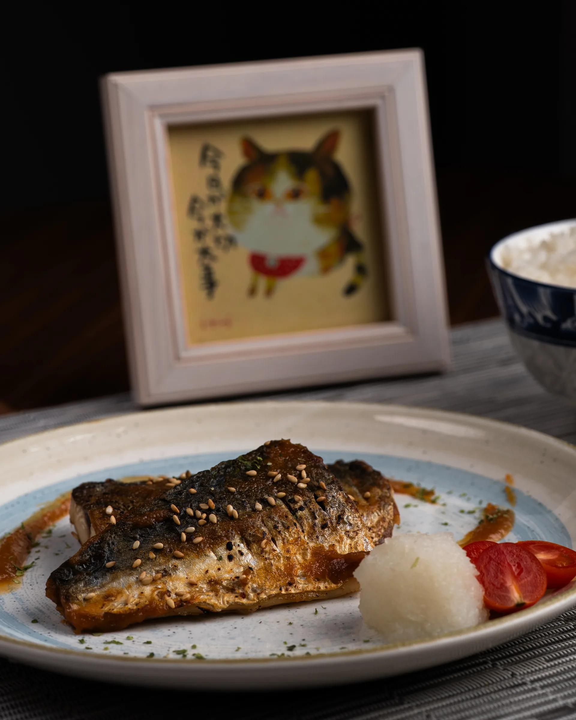 Porción de postre sobre un plato con una ilustración de gato al fondo.